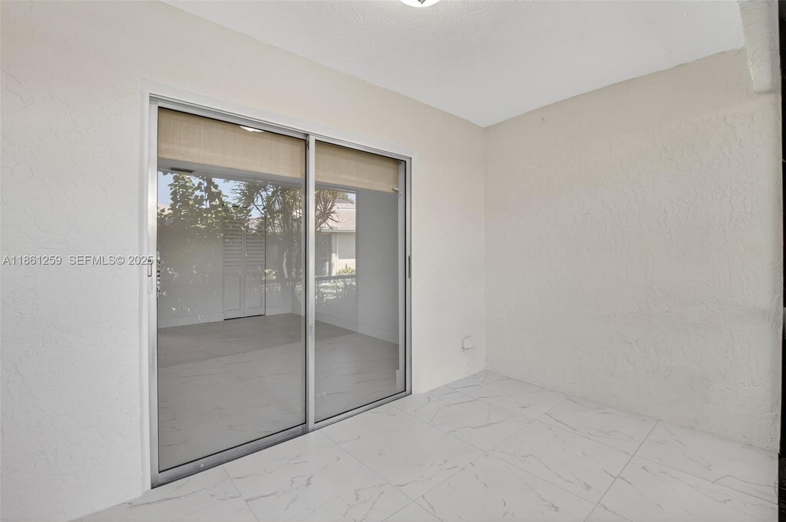 8840 Rheims Road Boca Raton, FL 33496 - Photo 24 of 41 an empty room with mirror in closet and a glass door