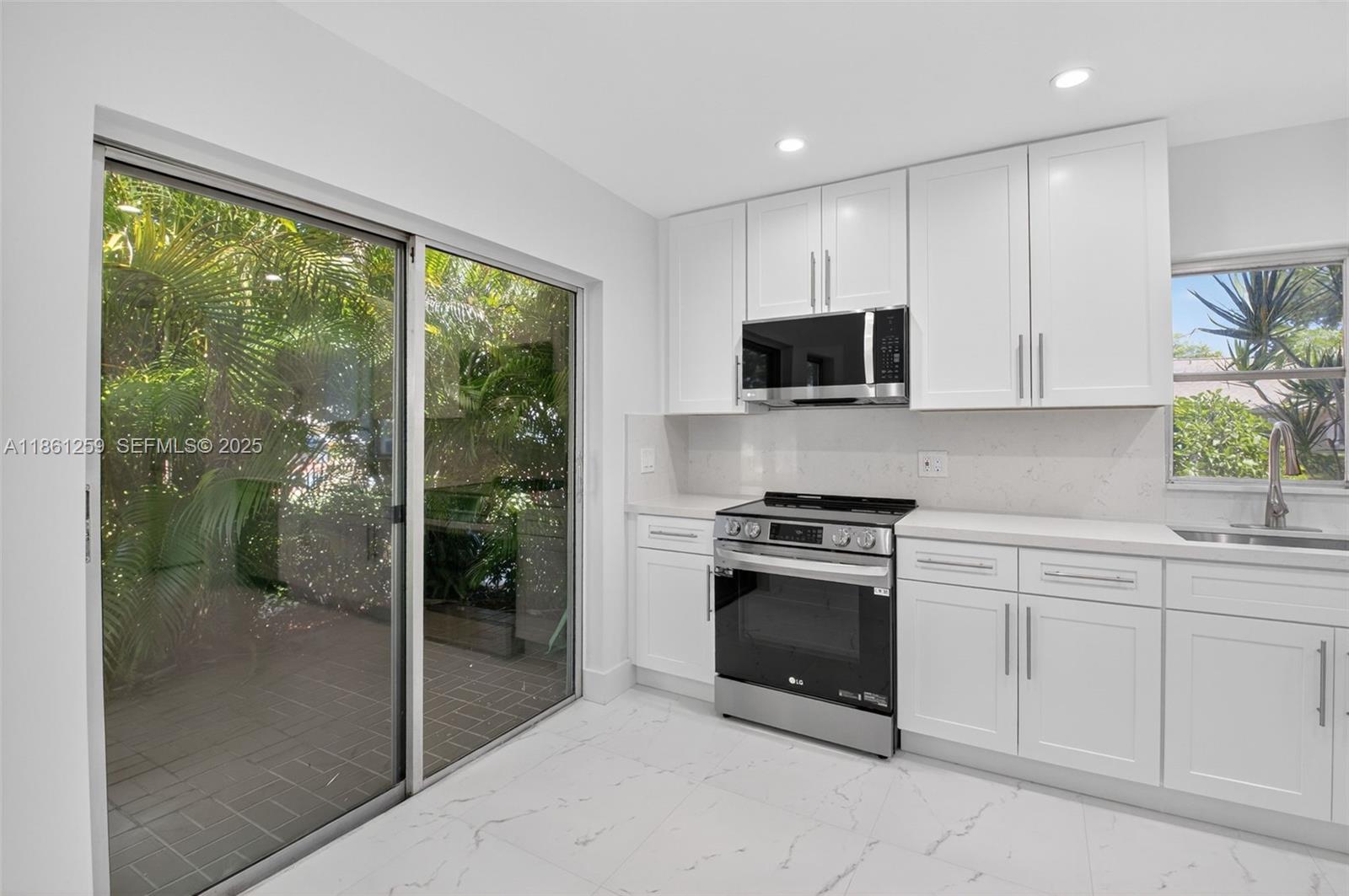 8840 Rheims Road Boca Raton, FL 33496 - Photo 4 of 41 a kitchen with a stove a sink and a microwave