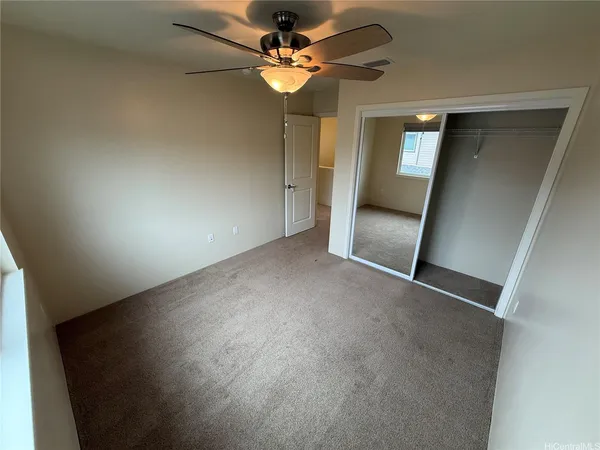 an empty room with fan and entrance