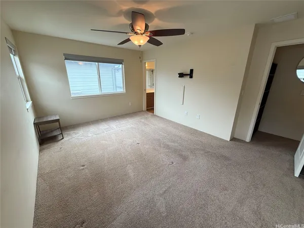 an empty room with a ceiling fan and a window