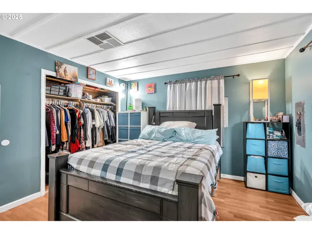 a bedroom with a bed a mirror and a desk