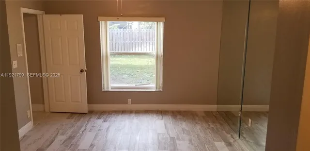 a view of a room with wooden floor and windows