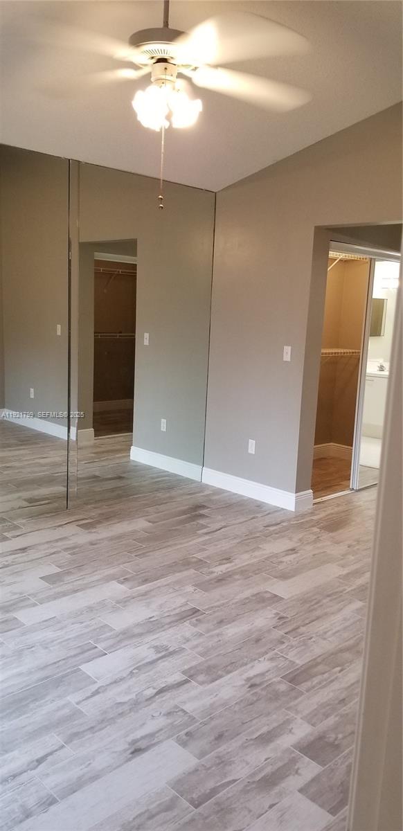 1972 Oak Berry Circle, Unit 1972 Wellington, FL 33414 - Photo 8 of 13 en empty room with wooden floor and fan