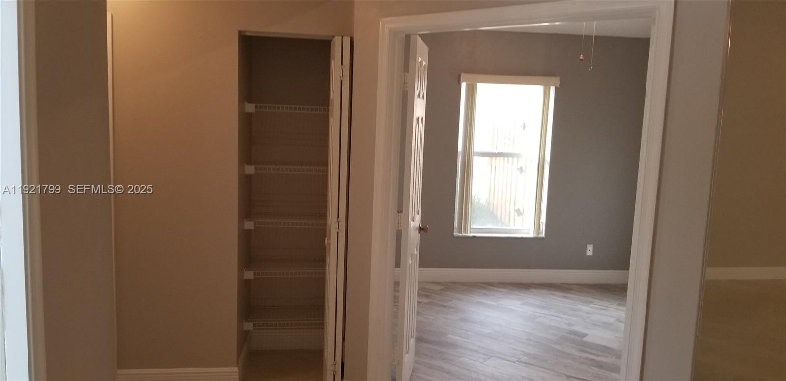 1972 Oak Berry Circle, Unit 1972 Wellington, FL 33414 - Photo 9 of 13 a view of an empty room with wooden floor and a window
