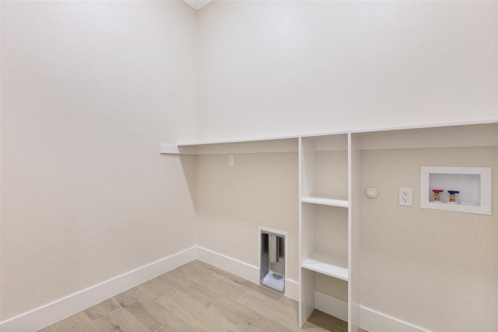 3150 Crisp Road Ennis, TX 75119 - Photo 21 of 30 Dedicated utility space featuring built-in shelving, a wall-mounted shelf, a dryer vent, and plumbing hookups