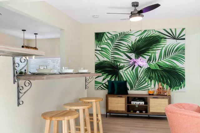 a living room with furniture a chandelier and a potted plant