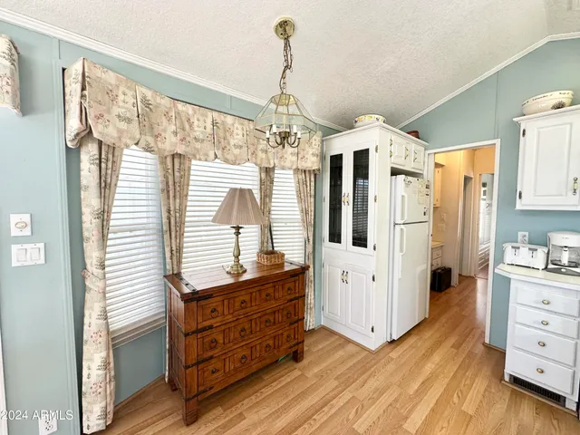 a room with lots of wooden furniture and chandelier