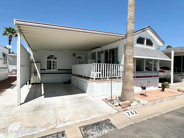 a view of a patio with a dining table and chairs with wooden floor and fence