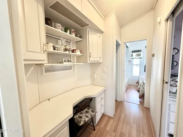a kitchen with white cabinets and wooden floor