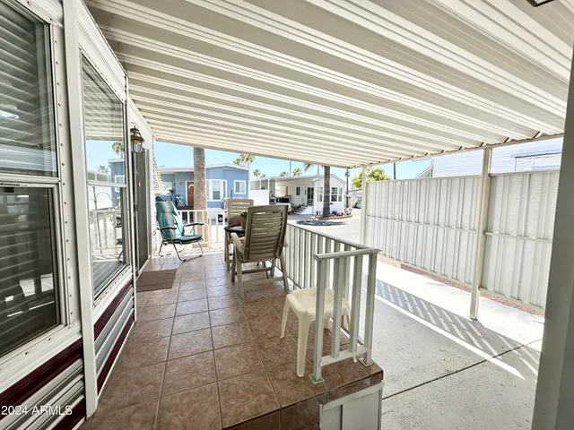 a view of a patio with a table and chairs and floor to ceiling window with wooden floor