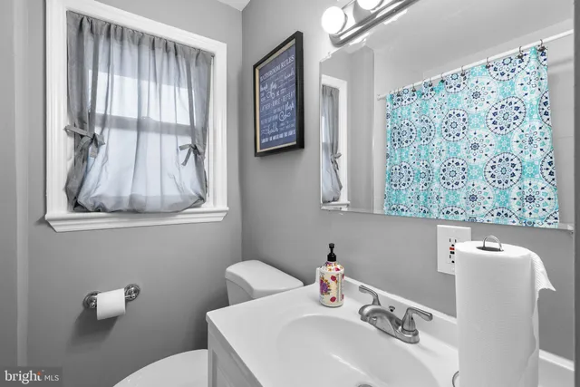 a bathroom with a sink mirror and a toilet