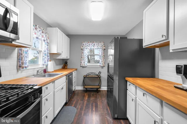 a kitchen with granite countertop a sink stove and refrigerator