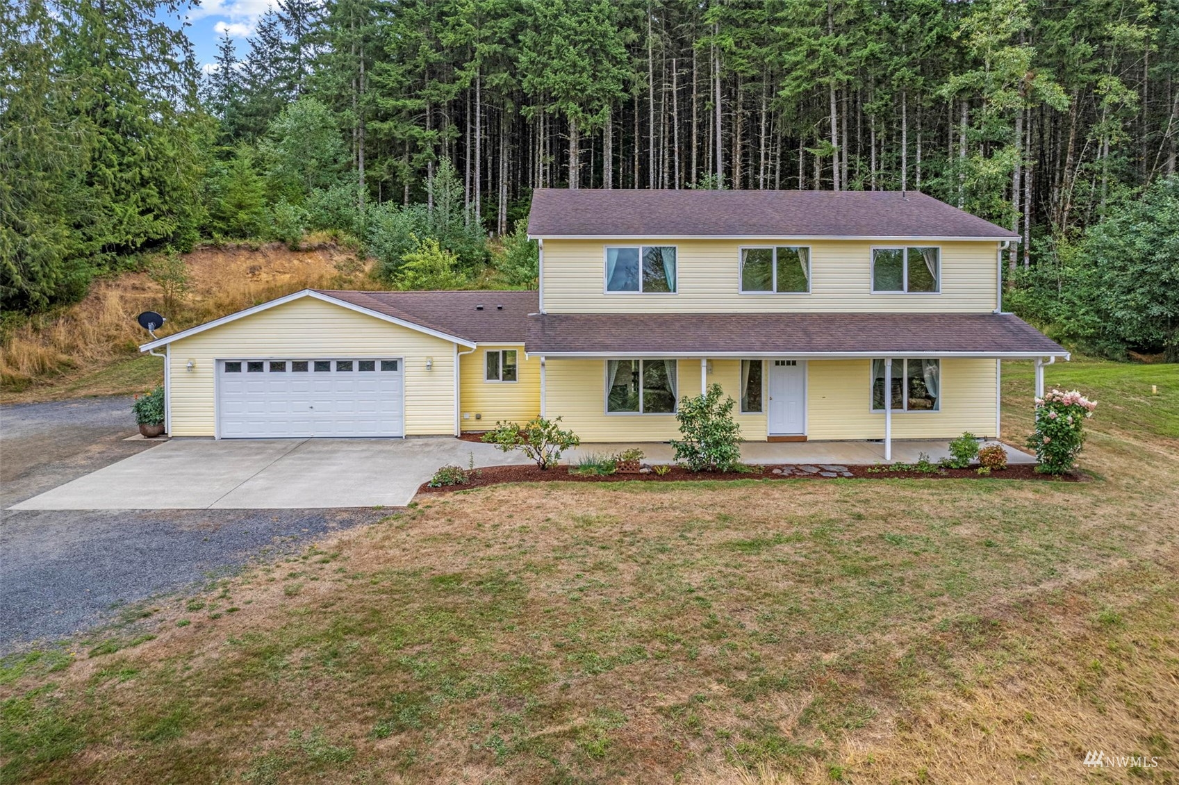658 Smokey Valley Road Toledo, WA 98591 - Photo 1 of 40 a view of a white house with large windows and a table and chairs under an umbrella