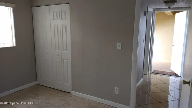 an empty room with windows and closet