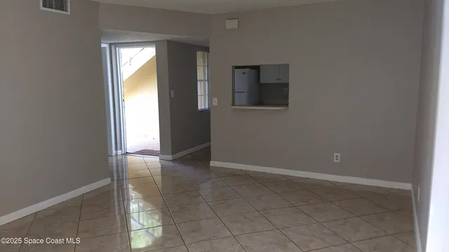 an empty room with mirror and windows