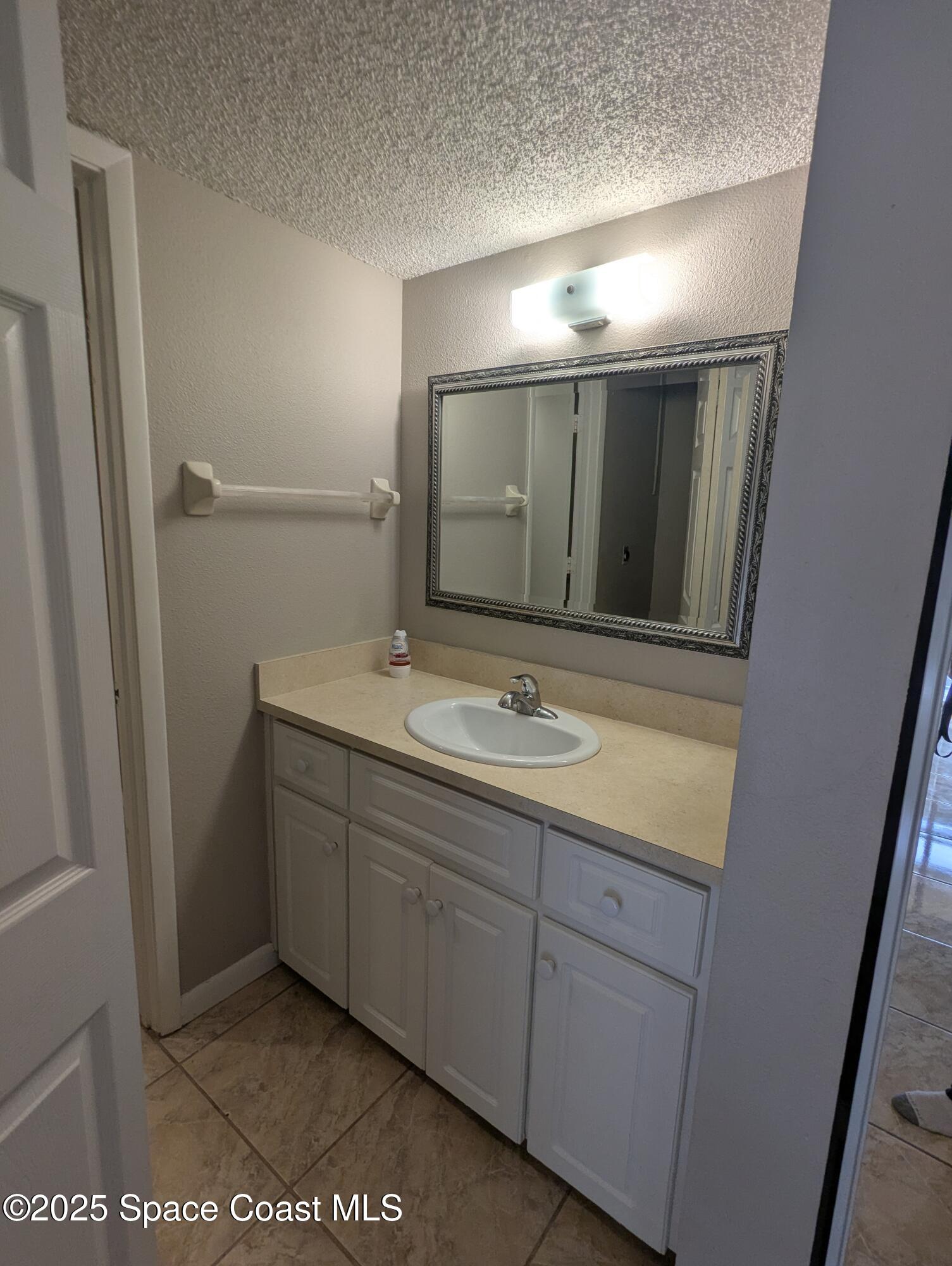 1609 Sunny Brook Lane, Unit E 104 Palm Bay, FL 32905 - Photo 22 of 31 a bathroom with a sink and mirror
