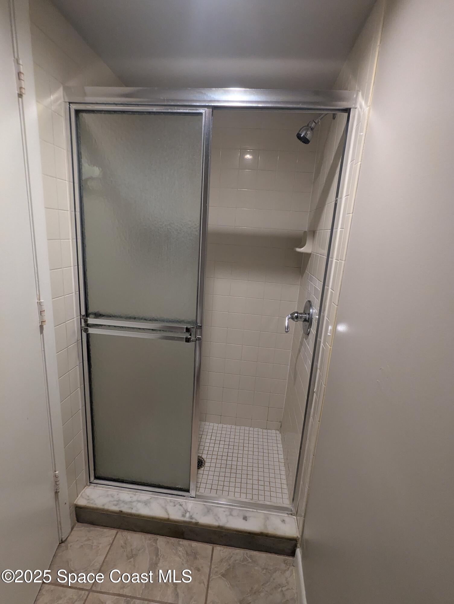 1609 Sunny Brook Lane, Unit E 104 Palm Bay, FL 32905 - Photo 24 of 31 a bathroom with a glass door shower