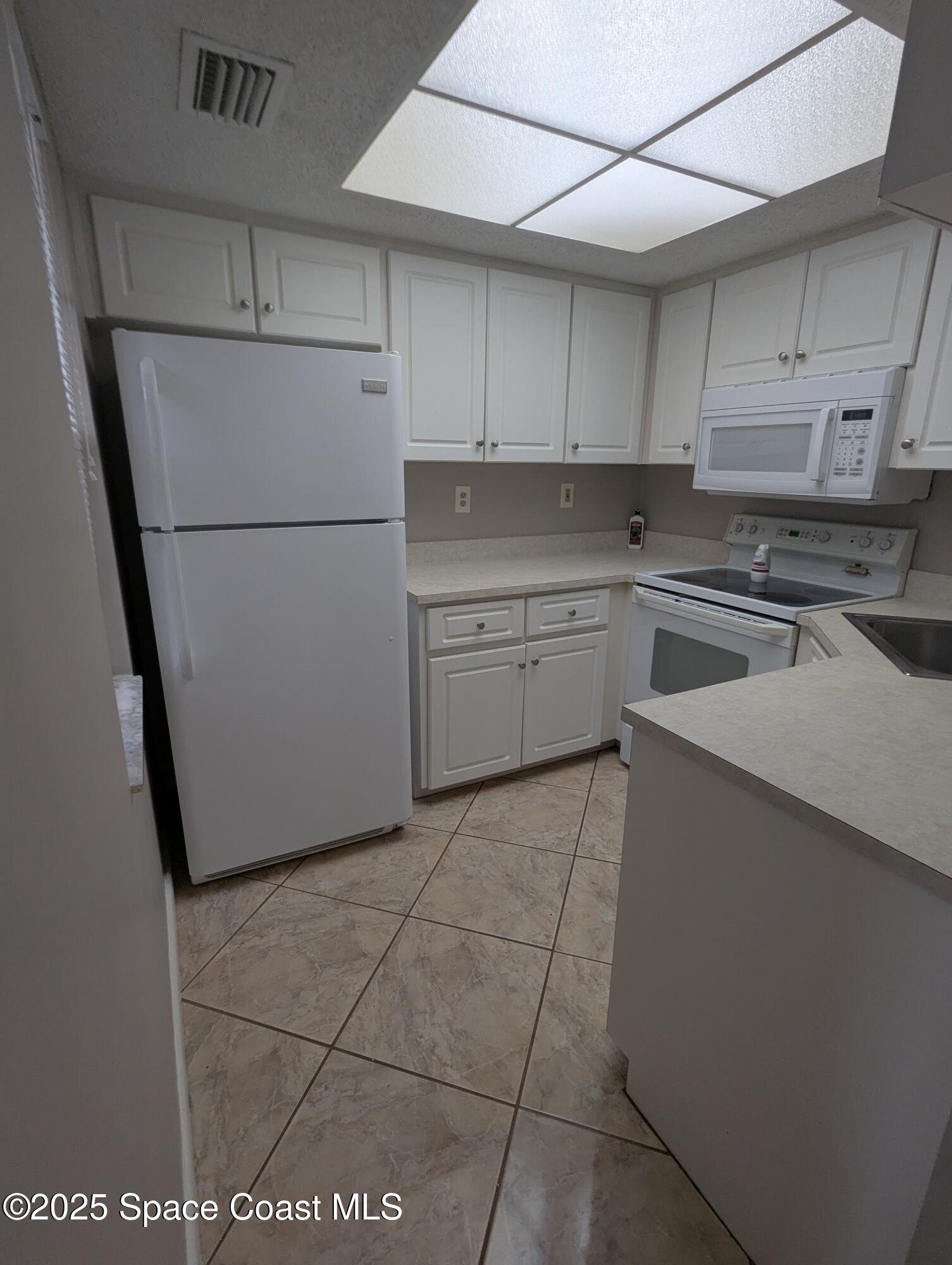 1609 Sunny Brook Lane, Unit E 104 Palm Bay, FL 32905 - Photo 4 of 31 a kitchen with a cabinets and a stove top oven