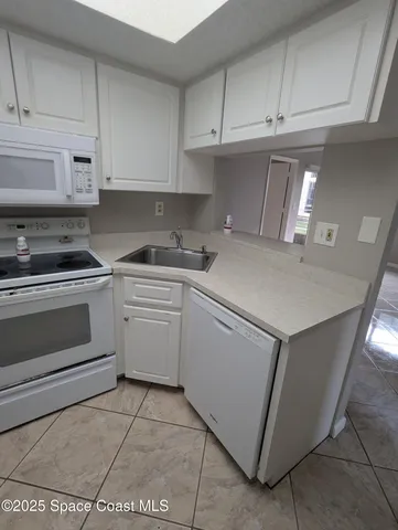 a kitchen with white cabinets and white appliances