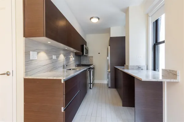 a kitchen with stainless steel appliances granite countertop a sink and a stove