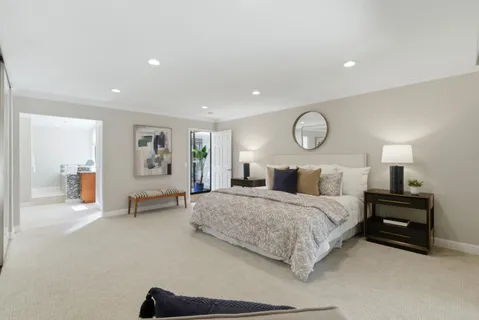 a bedroom with a bed and a large mirror