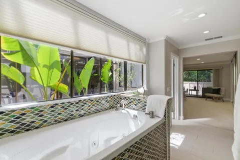 a bath room with a bed and a large window