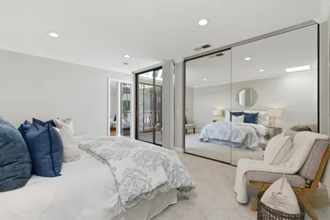 a bedroom with a bed large window and couch
