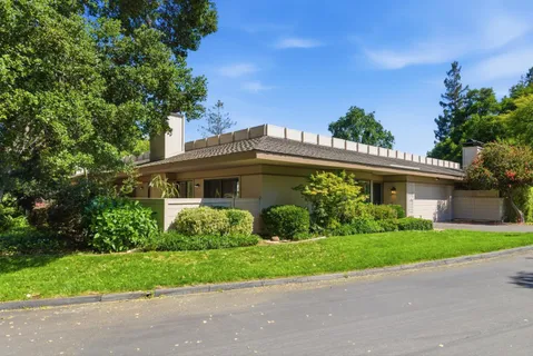 a front view of a house with a garden