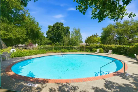 a view of a swimming pool and trees in the background