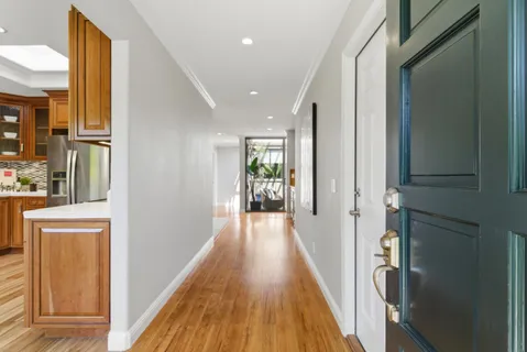 a view of a hallway with wooden floor and staircase
