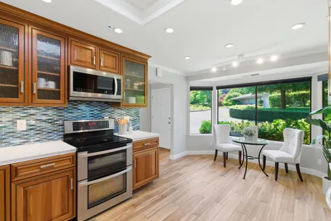 a kitchen with stainless steel appliances a stove top oven a sink and cabinets