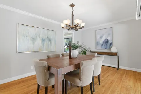 a view of a dining room with furniture wooden floor and a chandelier