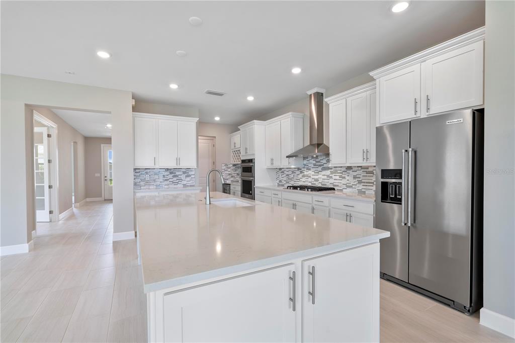 16056 Shoreline Drive Punta Gorda, FL 33982 - Photo 13 of 57 a large kitchen with stainless steel appliances a refrigerator and a stove top oven