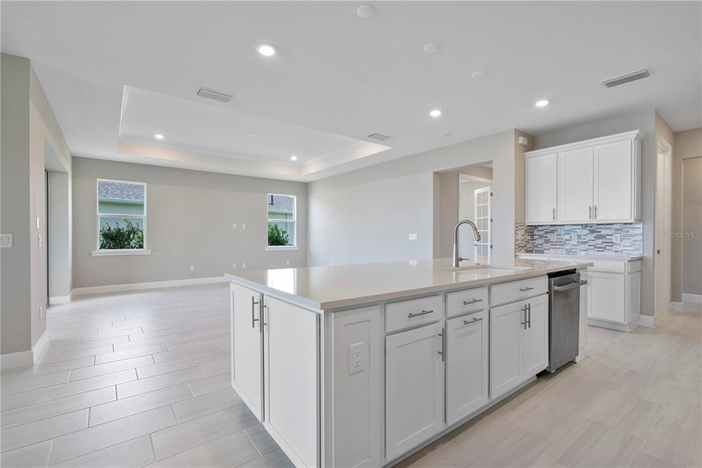 16056 Shoreline Drive Punta Gorda, FL 33982 - Photo 19 of 57 a kitchen with white cabinets appliances a sink and a window
