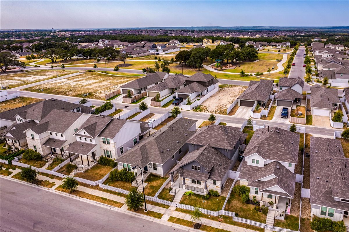 223 Rieber Road Kyle, TX 78640 - Photo 30 of 40 An aerial view showcases a modern residential neighborhood structured with clean sidewalks and landscaped yards.