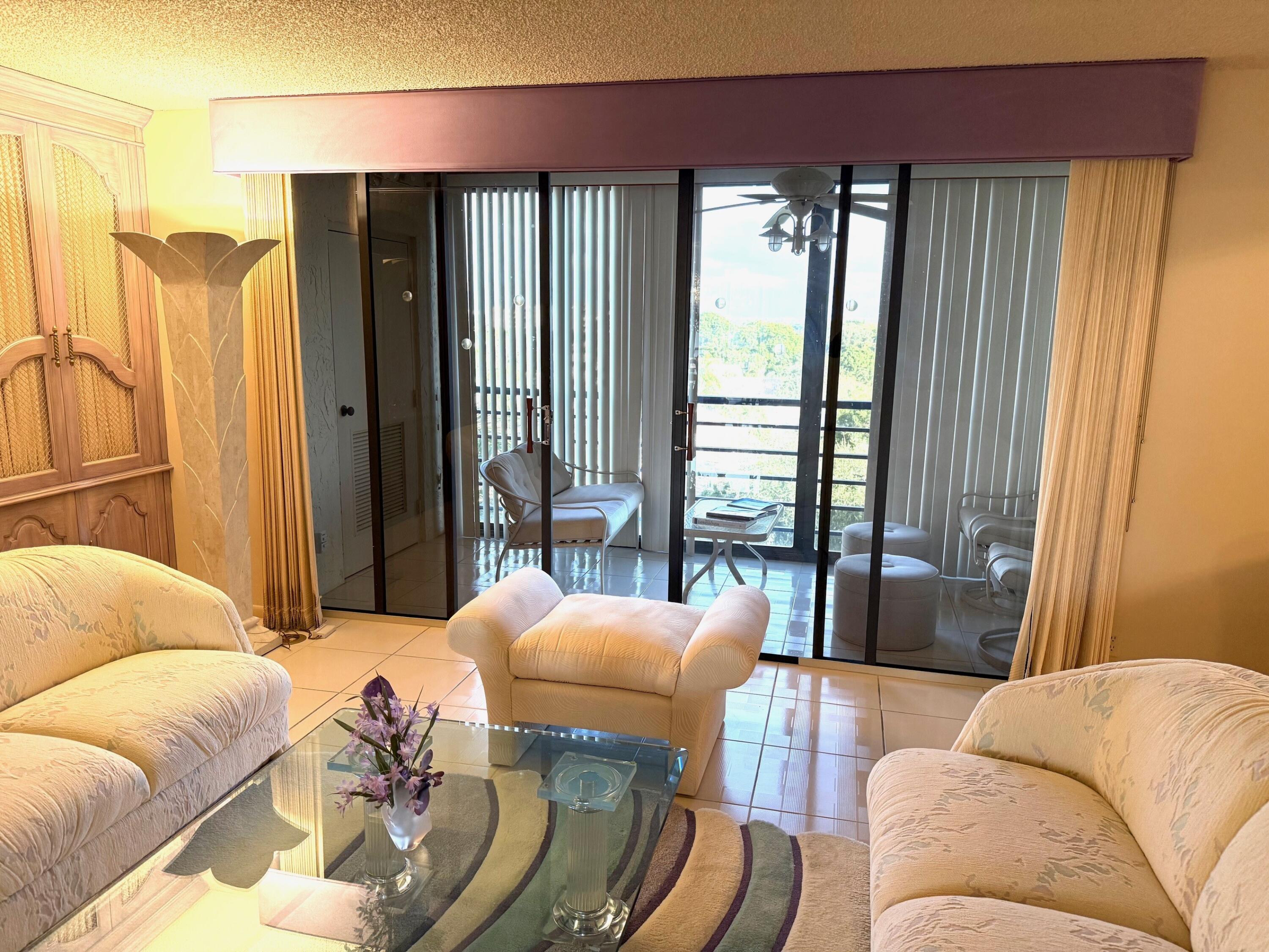 7564 Regency Lake Drive, Unit 702 Boca Raton, FL 33433 - Photo 12 of 40 a living room with furniture and a large window