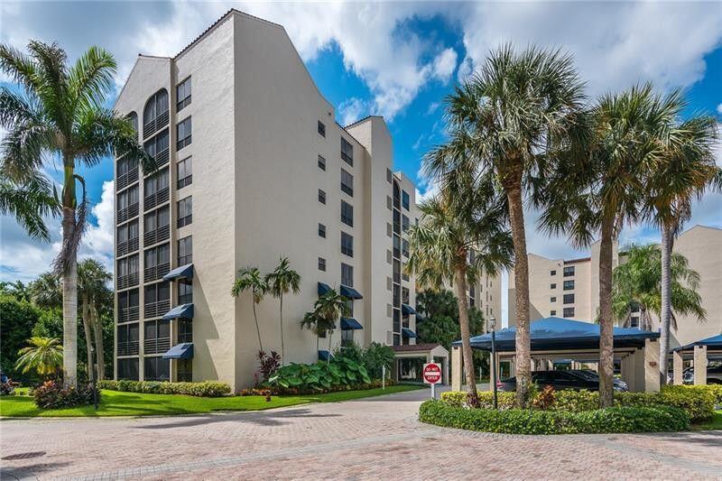 7564 Regency Lake Drive, Unit 702 Boca Raton, FL 33433 - Photo 38 of 40 a front view of multi story residential apartment building with yard and green space