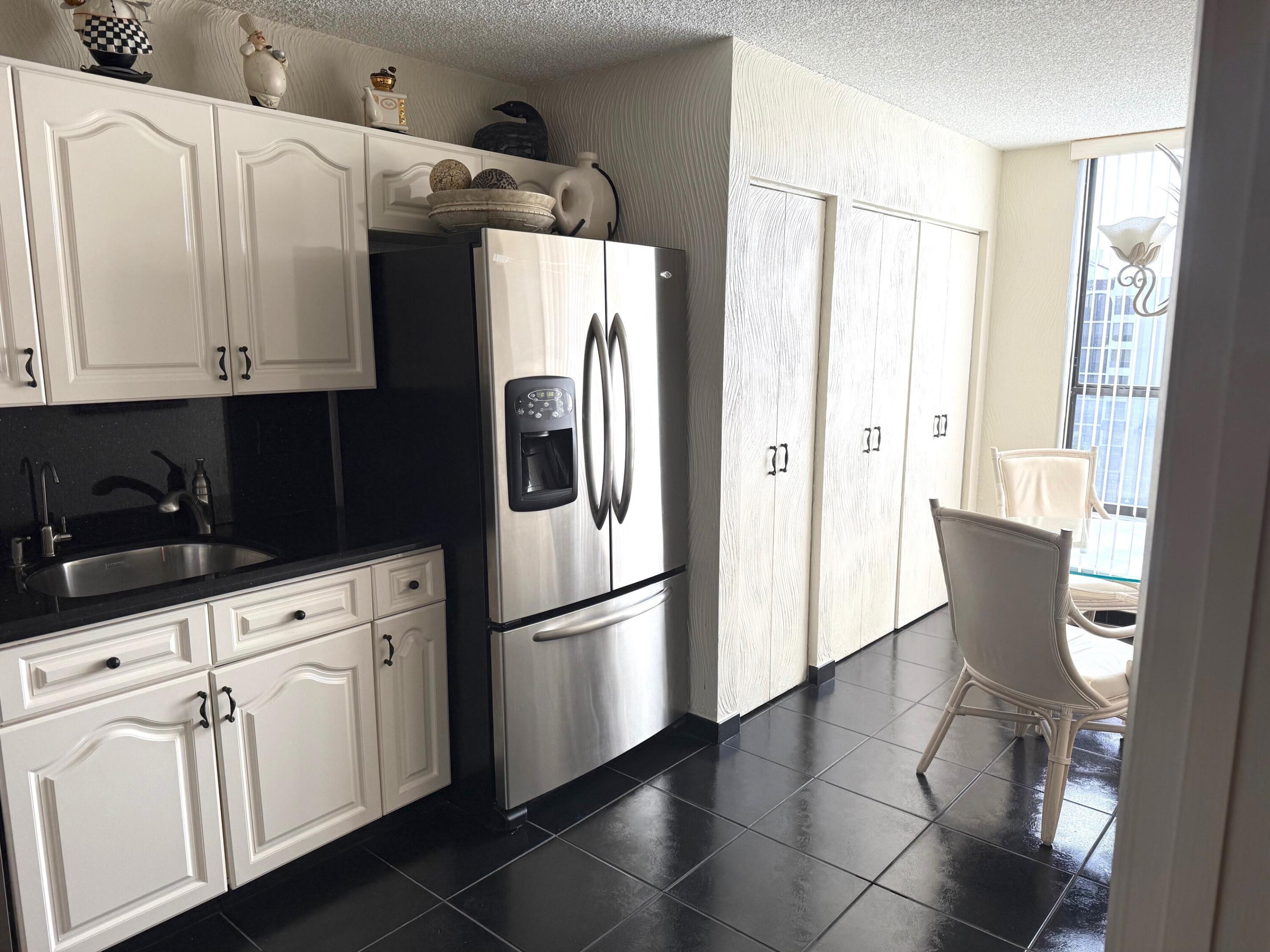 7564 Regency Lake Drive, Unit 702 Boca Raton, FL 33433 - Photo 4 of 40 a kitchen with stainless steel appliances a refrigerator and cabinets