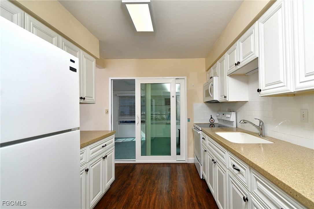 13 Hamlin Court Lehigh Acres, FL 33936 - Photo 12 of 31 a kitchen with granite countertop a sink stove and refrigerator