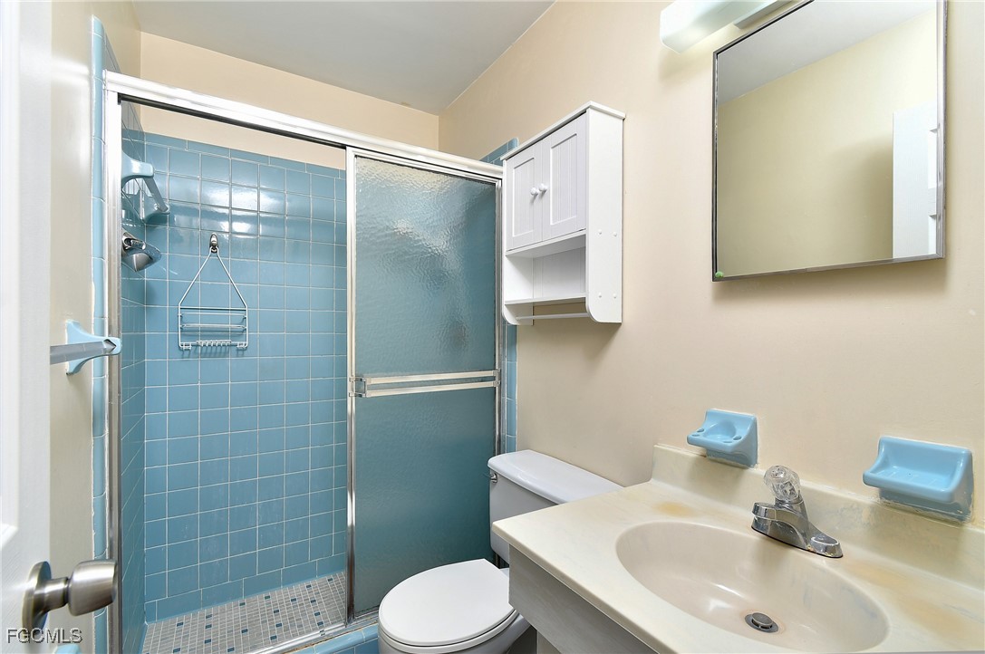 13 Hamlin Court Lehigh Acres, FL 33936 - Photo 16 of 31 a bathroom with a sink toilet and shower