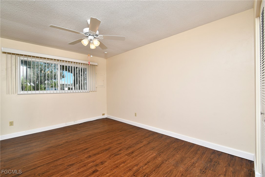 13 Hamlin Court Lehigh Acres, FL 33936 - Photo 17 of 31 a view of an empty room with wooden floor and a window