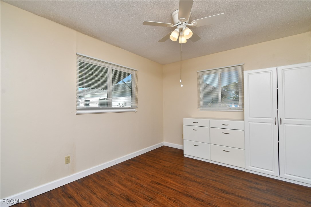13 Hamlin Court Lehigh Acres, FL 33936 - Photo 20 of 31 a view of an empty room with wooden floor and a window