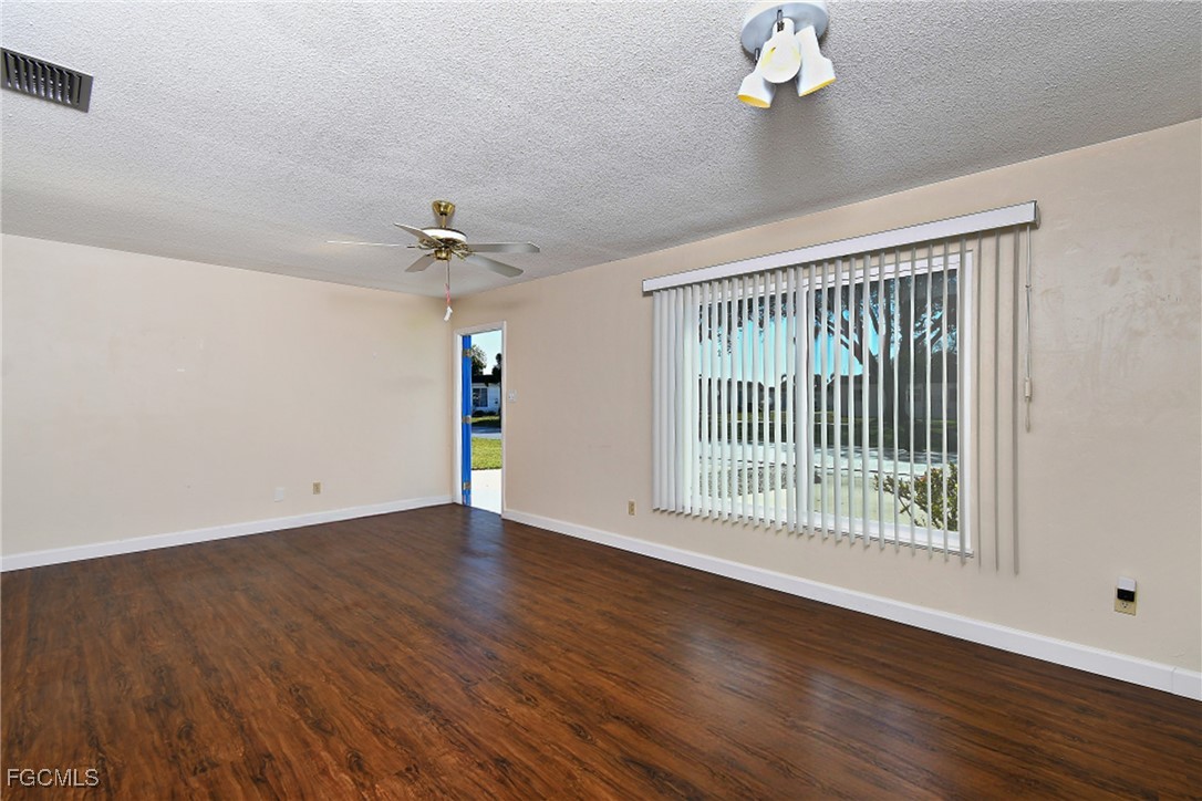 13 Hamlin Court Lehigh Acres, FL 33936 - Photo 7 of 31 a view of an empty room with a window and wooden floor