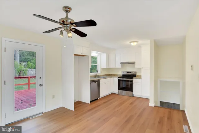 a kitchen with a stove a sink and a window