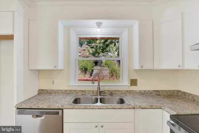a kitchen with granite countertop a sink and a window