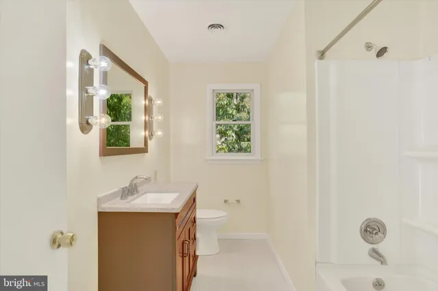 a bathroom with a toilet a sink and a mirror