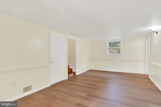 a view of a room with wooden floor and white walls