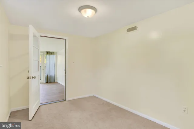 an empty room with kitchen and windows