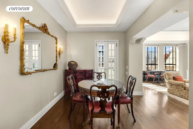 a bedroom with a bed a mirror on dresser and a wooden floor