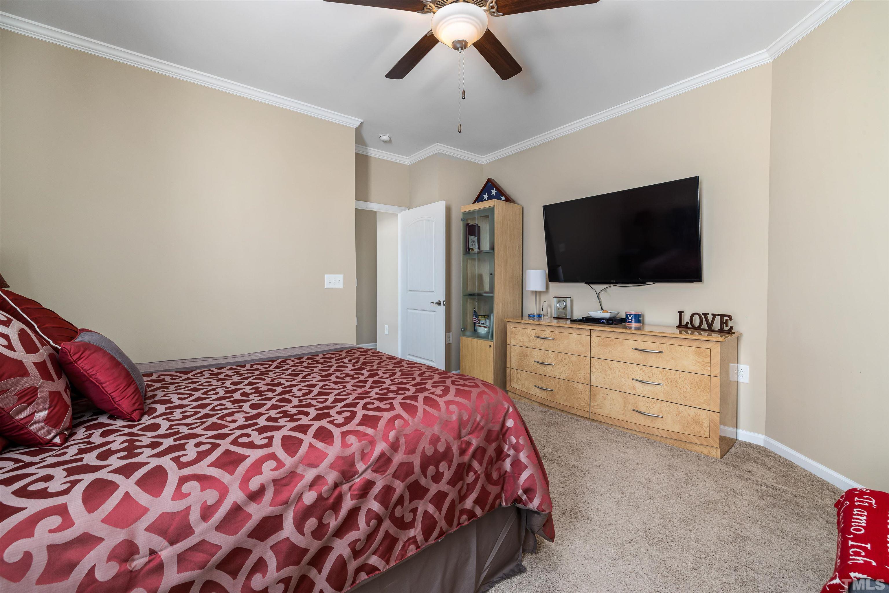 1115 Hooper Place Durham, NC 27703 - Photo 23 of 40 a bedroom with a bed and a flat tv screen on dresser